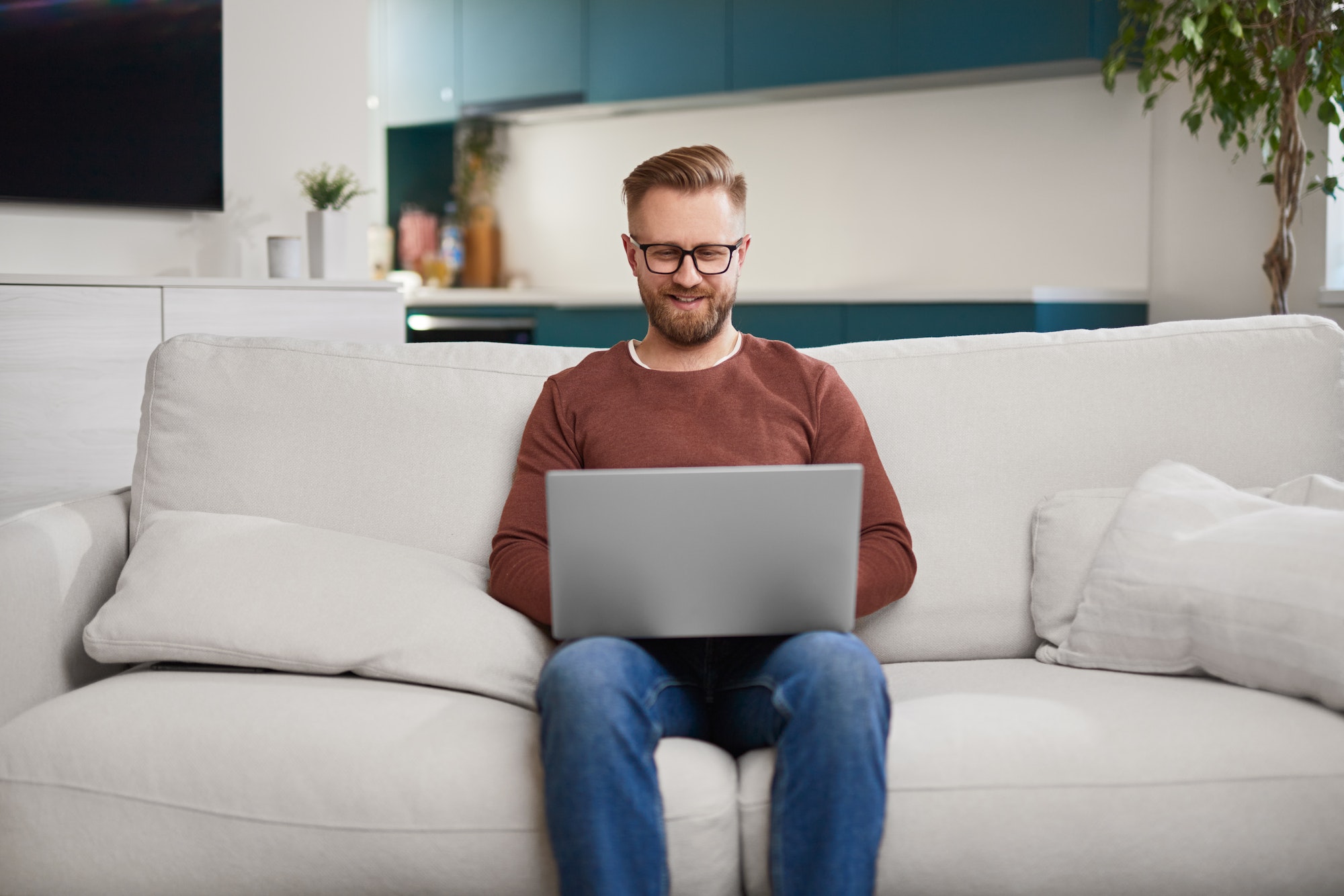 Smiling self employed man working on laptop at home